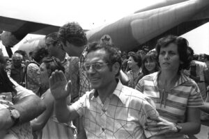 A JOYOUS WAVE OF HAND AND A TENSE SEARCHING LOOK  BY HOME COMING AIR FRANCE HOSTAGES, RESCUED FROM ENTEBBE    AIRPORT.